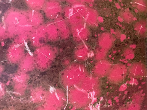 Red painted metal surface with dirty splotches