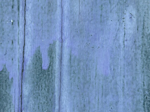 Old wood with purple paint mostly weathered away