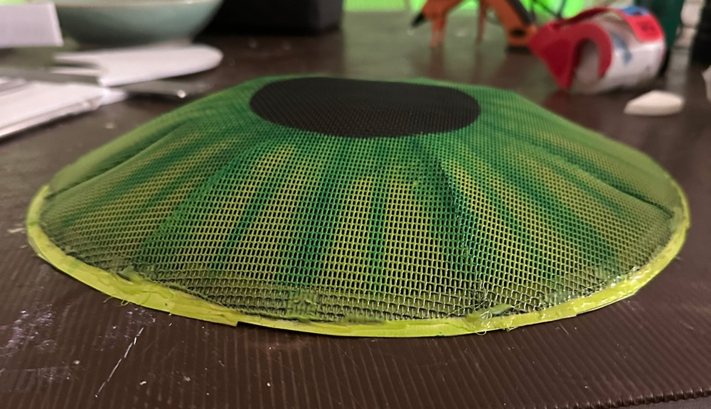 Side view of the iris/pupil screen, showing its subtle dome shape.