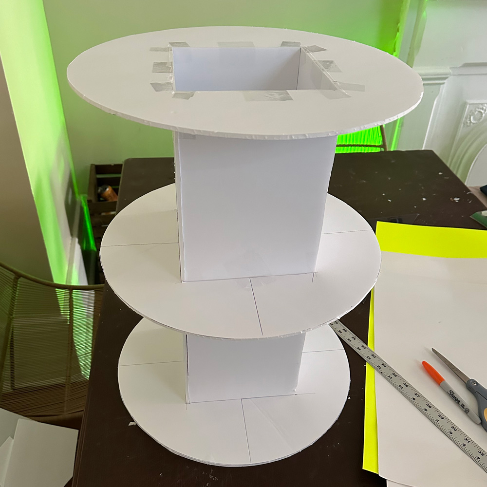 Three big foam board disks attached to a vertical foam board column; one disk at the top, one in the middle, and one at the bottom.