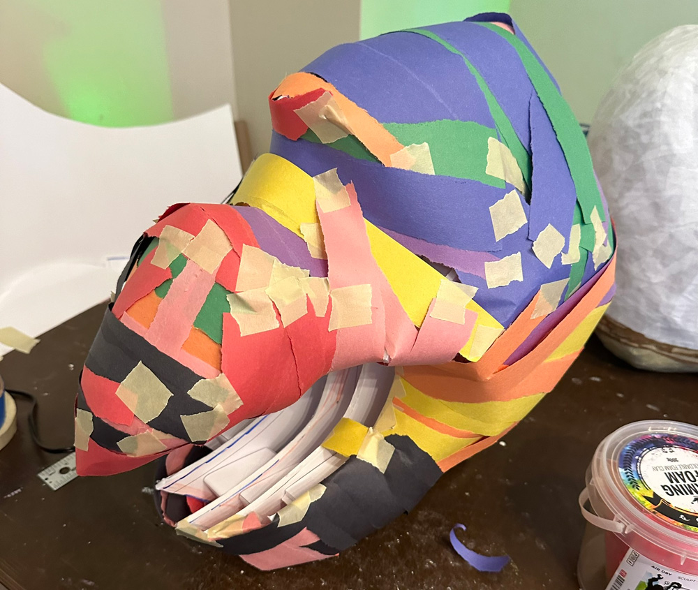 Covering the mask with strips of construction paper