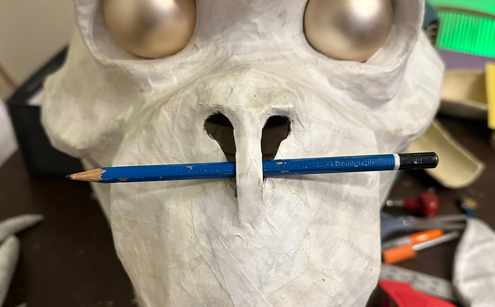 Front view of the mask showing a pencil going through the nostrils