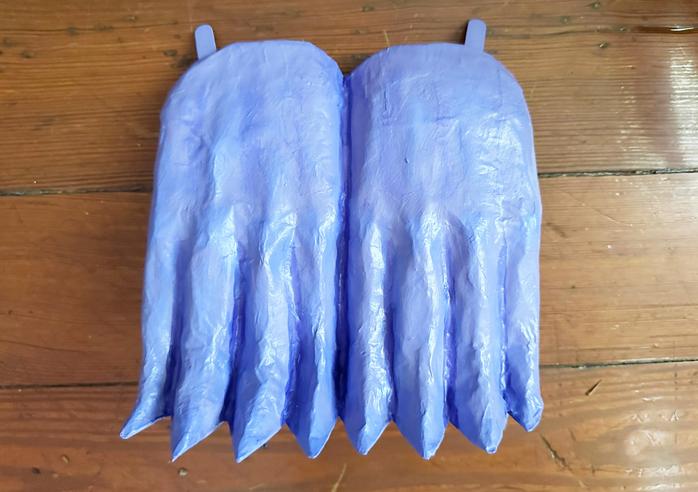 Paper mache gargoyle hands with little wooden tabs sticking out of the top
