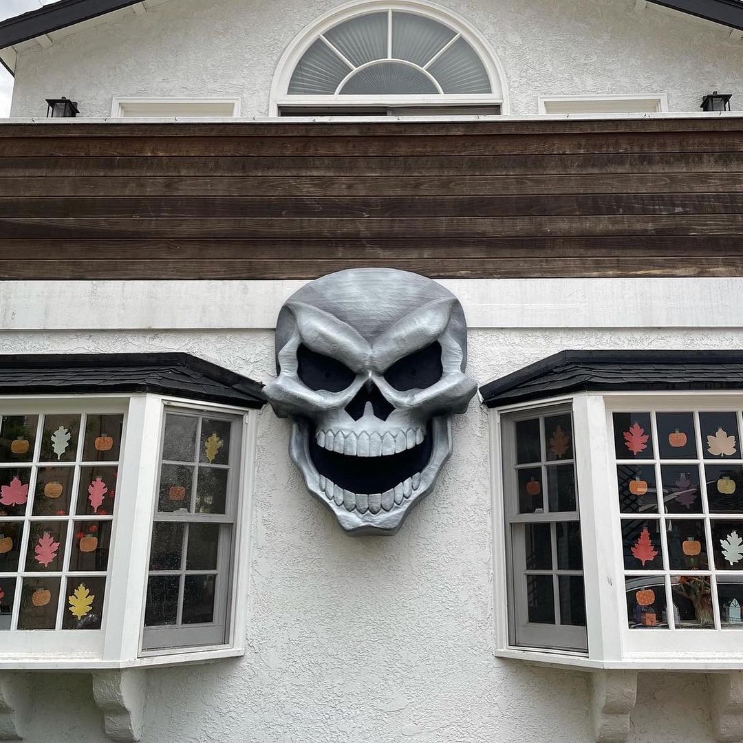 Giant paper mach&eacute; skull Halloween decoration - hanging on house
