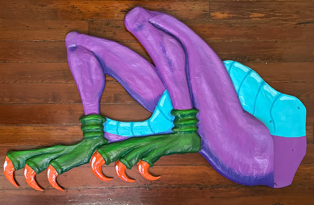 The legs/belly component with painting completed; the legs are purple, he's wearing green socks with the toes cut off, and orange claws are poking out. His belly is a teal color with darker teal lines running across it.