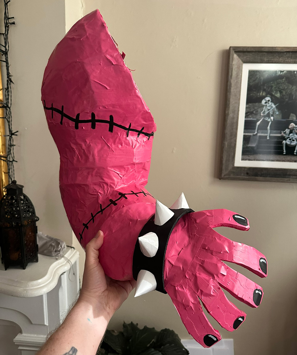 The pink monster arm now has black stitches drawn on, as well as black fingernails and a spiky bracelet.