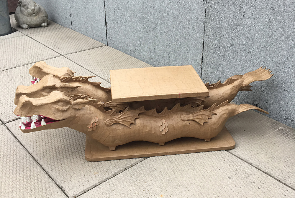 Dragon sculpture covered in brown paper mache, not yet painted.
