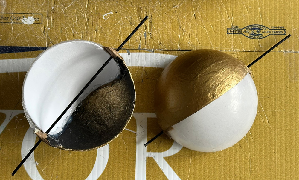 The eyes; two hollow half-spheres with one half painted gold and the other translucent white.
