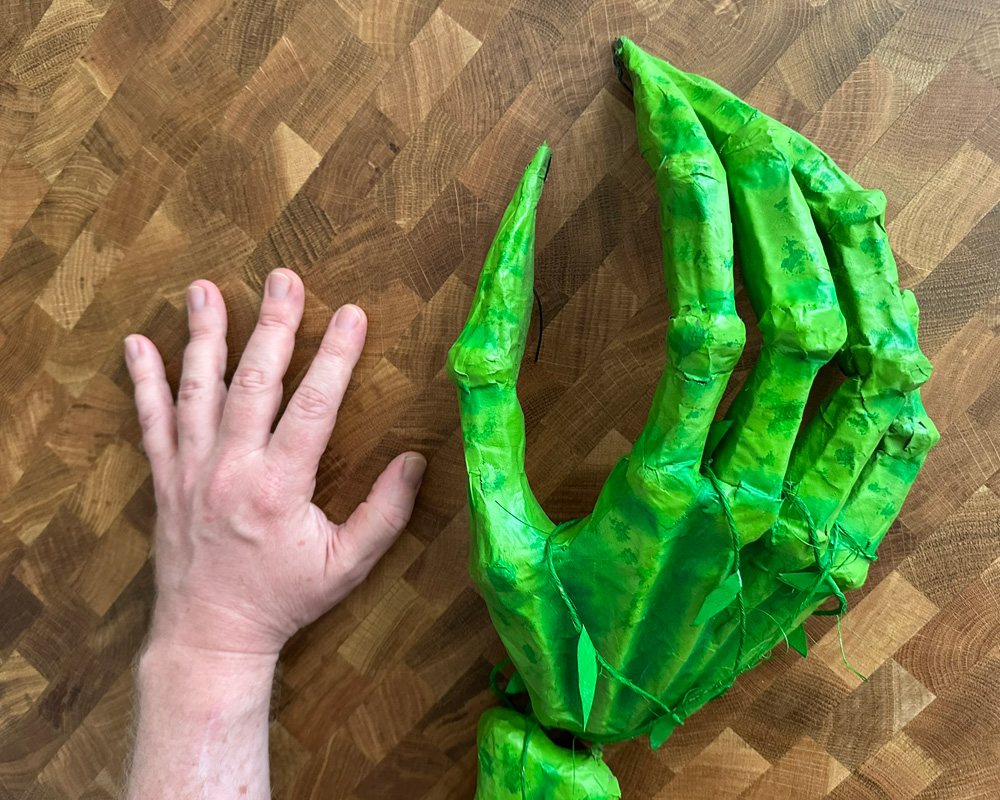 My hand next to the skeletal witch's hand for scale; my hand is about half the size of the witch hand.
